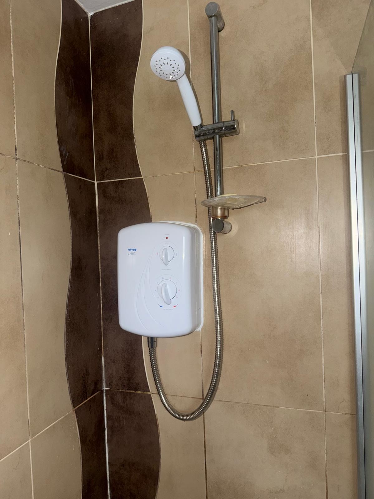Triton electric shower installed in a tiled cubicle by Semico Plumbers